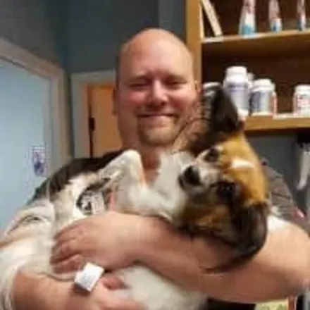 Dr. Robert Walker's staff photo from Strawbridge Animal Care where he is holding a fluffy dog.